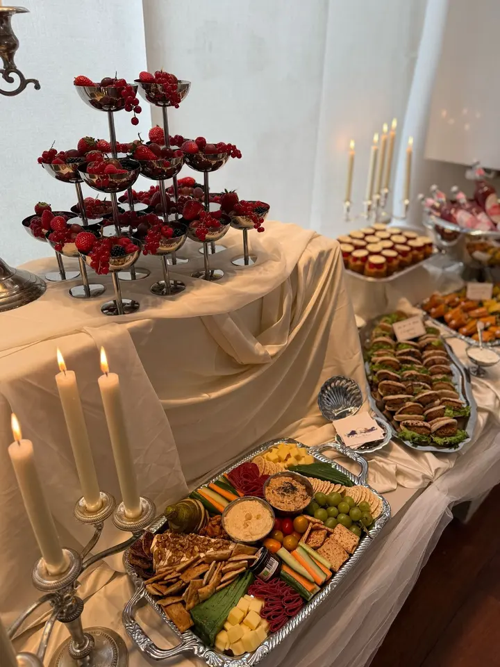 Buffet met beige draperie, etagères en zilveren schalen