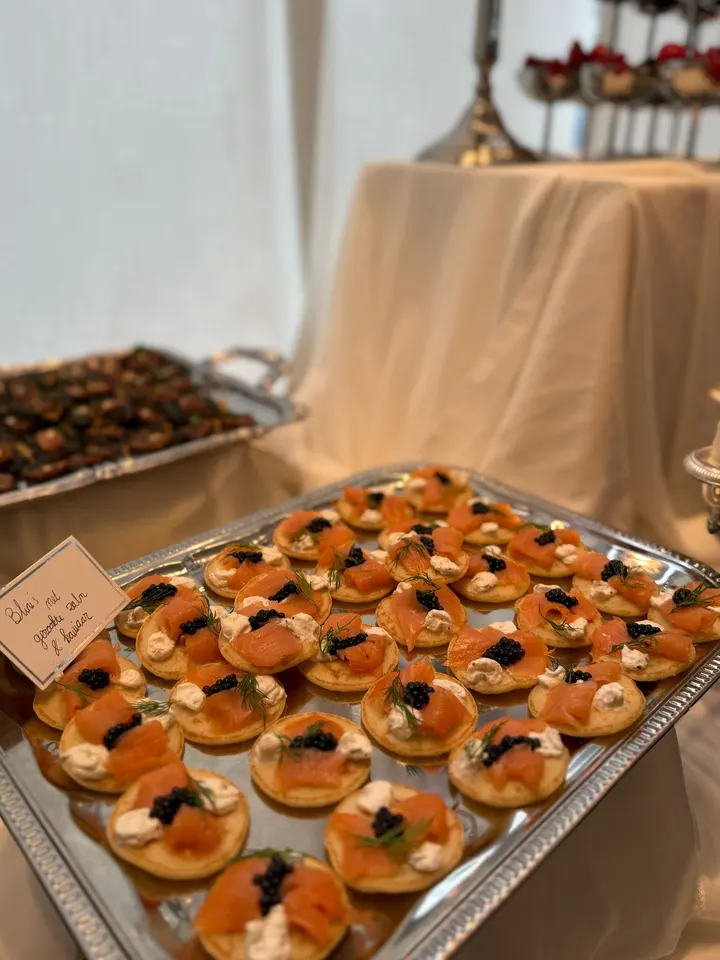 Zilveren schaal met blini's met gerookte zalm, roomkaas en kaviaar