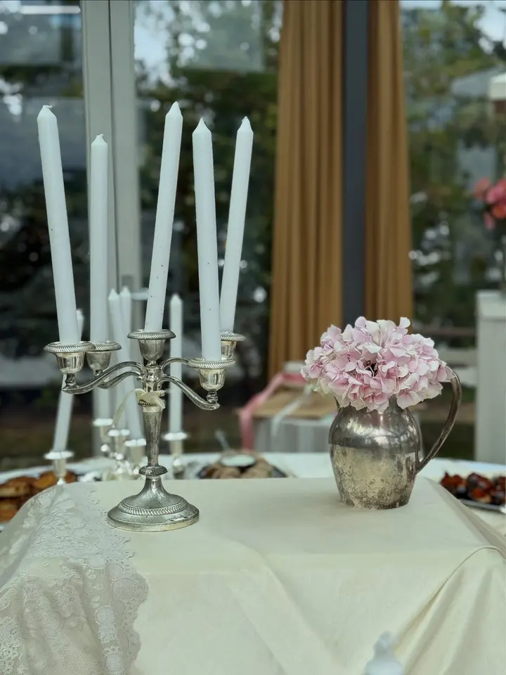 Babyshower-tafel met kandelaars en roze bloemen