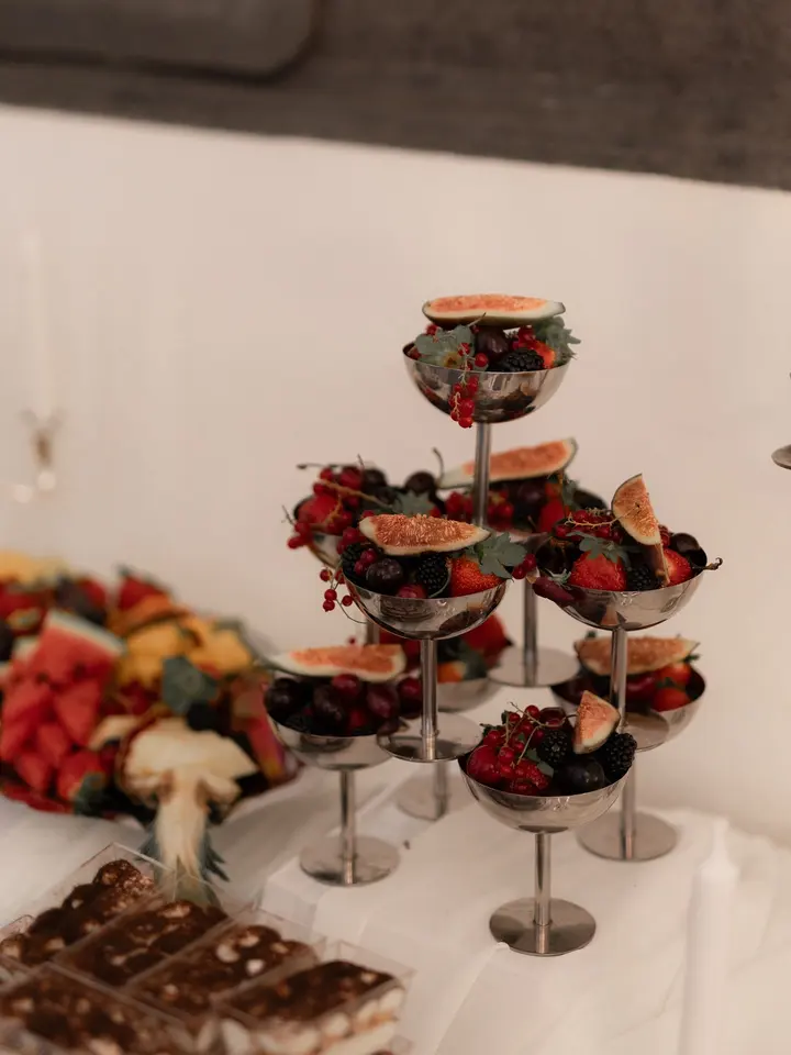 Glazen etagères met kleine desserts, vijgen en bessen